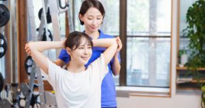 パーソナルトレーナーによるストレッチ指導を受ける女性のイメージ